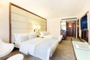 Postel nebo postele na pokoji v ubytování Regal Kowloon Hotel