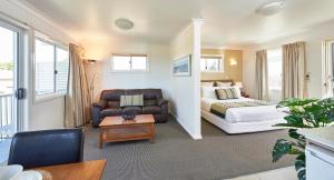 a living room with a bed and a couch at Harbour View Apartments in Ulladulla