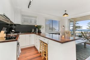 een keuken met witte kasten en een aanrecht bij Beachfront on Golden Mile in Sydney