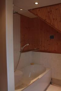 a bath tub with a shower in a bathroom at Harbour House Bed & Breakfast - Wick in Wick