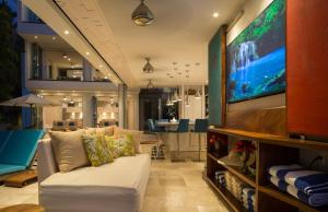 een woonkamer met een bank en een flatscreen-tv bij Anjali Casa Divina in Sayulita