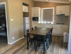 a kitchen and dining room with a table and chairs at Treehaven Tourist Park in Bomaderry