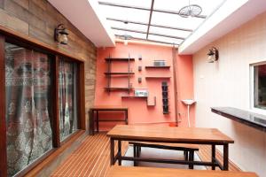 ein Esszimmer mit einem Holztisch und orangefarbenen Wänden in der Unterkunft Ekam Lodge in Nainital