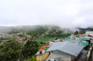 a view of a city with a river and buildings at Ekam Lodge in Nainital