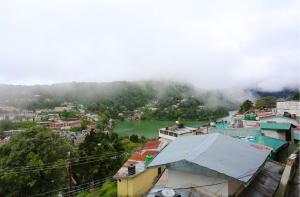 a view of a city with a river and buildings at Ekam Lodge in Nainital