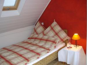 a bed in a room with a table with a lamp at Gästehaus By George in Stolberg