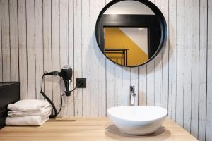 a white toilet sitting under a mirror next to a sink at Hotel Brouwerij Het Anker in Mechelen