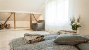 a bedroom with a bed with pillows and a chair at Best Stay- Pärnu With Garden in Pärnu