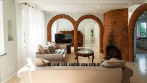 a living room with a couch and a brick fireplace at Best Stay-Pärnu Villa in Pärnu