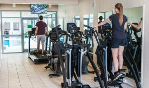 a woman standing on a treadmill in a gym at Hotel Marselis in Aarhus