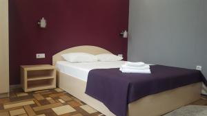 een slaapkamer met een bed en een tafel met handdoeken bij Hotel Vega in Krasnodar