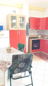 カプリオーリにあるVilla Serenaのキッチン(赤いキャビネット、テーブル、椅子付)