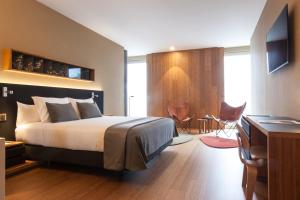 um quarto de hotel com uma cama e uma secretária em Ocean Drive Barcelona em Barcelona