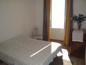 a bedroom with a bed and a chair and a window at Appartement Colonella in Bastia