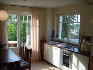 a kitchen with a table and some windows and a counter at Villa Amelie in Binz