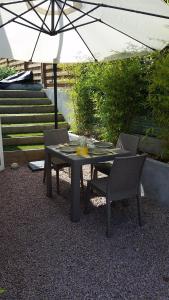 uma mesa com duas cadeiras e um guarda-sol em T2 de 45 m2 sur Porticcio avec Jardin em Porticcio