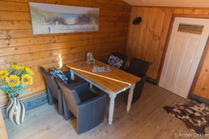 a dining room with a wooden table and chairs at Vrijstaande blokhut in Egmond-Binnen