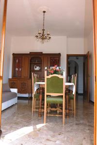 een eetkamer met een tafel met stoelen en een kroonluchter bij casa di erika in Varazze
