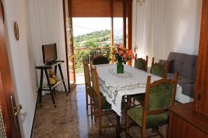 a dining room with a table and chairs and a television at casa di erika in Varazze