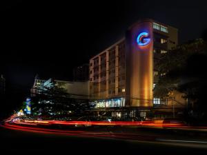 a building with a sign on the side of it at night at Hotel G Yangon in Yangon
