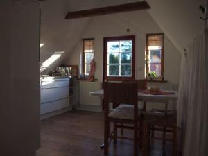 una cucina con tavolo e sedie e una cucina con lavandino di Reetdach - Promenadenblick - 500m zum Strand a Prerow