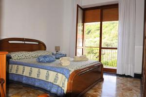een slaapkamer met een bed en een groot raam bij casa di erika in Varazze