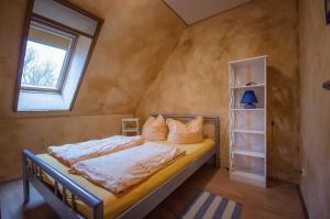 ein Schlafzimmer mit einem Bett in einem Zimmer mit einem Fenster in der Unterkunft Pferdehof Ranzow in Ranzow