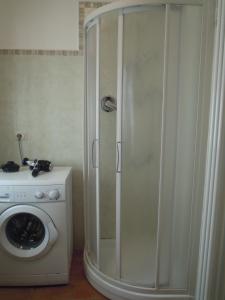 a shower in a bathroom with a washing machine at Cascina Formighezzo in Arquata Scrivia