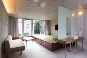 a bathroom with a sink and a couch and a mirror at URBAN LODGE Komagome in Tokyo