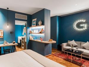uma sala de estar com uma cama e uma parede azul em Hotel G Yangon em Yangon