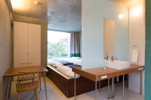 a bedroom with a bed and a sink and a mirror at URBAN LODGE Komagome in Tokyo +106 photos