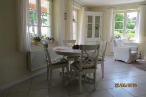 a dining room with a table and chairs and windows at Landhaus Klein Kubitz WE8864 in Ummanz