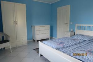 UmmanzにあるLandhaus Klein Kubitz WE8864の青い壁のベッドルーム1室(ベッド1台付)