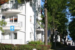 un edificio blanco con una señal azul delante de él en Komfortferienwohnung Strandgut, en Sassnitz
