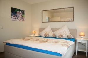 Un dormitorio con una cama con un espejo en la pared. en Komfortferienwohnung Strandgut, en Sassnitz