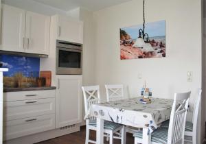 Una cocina con mesa de comedor y sillas. en Komfortferienwohnung Strandgut, en Sassnitz 14 fotos más