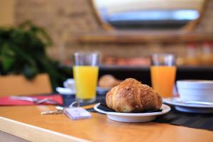 a table with a plate of food and two glasses of orange juice at Double B Maison De Charme in Alghero