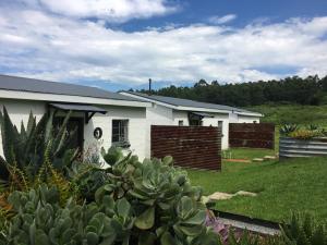 a white house with a fence in a yard at The Old Mushroom Farm in Howick