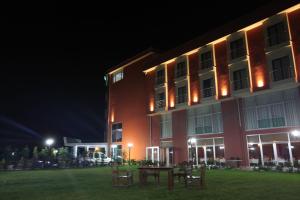 Velimeşe的住宿－新羅酒店，一座在晚上有桌子的建筑