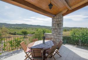 een patio met een tafel en stoelen op een balkon bij Les 23 Mûriers in Chauzon