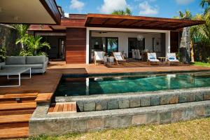 a swimming pool in the backyard of a house at Coral Villa in Cap Malheureux