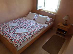 a bedroom with a bed with a comforter and a window at Apartmani Amaro in Novi Sad