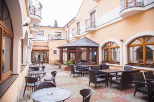 a patio with tables and chairs in a building at Hotel Eminent in Zlaté Moravce