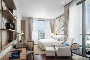 バンコクにある137 ピラーズ レジデンシーズ バンコクのベッド、テーブル、椅子が備わるホテルルームです。