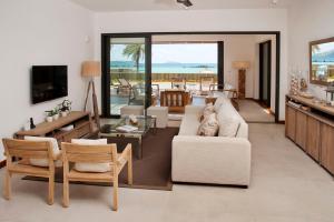 a living room with a couch and a table and a television at Coral Villa in Cap Malheureux