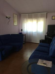 Sala de estar con 2 sofás azules y TV en Magenta, en Vittuone