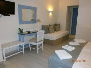 a living room with a bed and a desk in a room at Alkyoni Beach Hotel in Naxos Chora