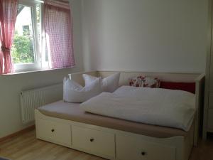 ein Bett mit weißer Bettwäsche und Kissen in einem Schlafzimmer in der Unterkunft Petite Bellevue II in Baden-Baden