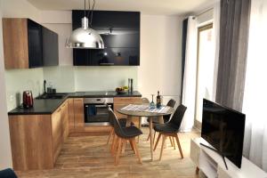 kuchnia ze stołem i krzesłami w kuchni w obiekcie Windrose Apartment w Świnoujściu