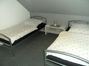 two twin beds in a room with a night stand at Komfort_Ferienwohnung in Geldern